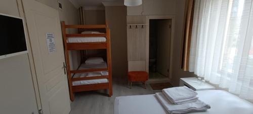 a room with a bunk bed and a room with two beds at Hotel Crowded House in Eceabat