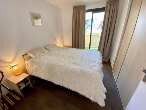 une chambre avec un lit blanc et une fenêtre dans l'établissement Quiet sea view with pool, à Cannes