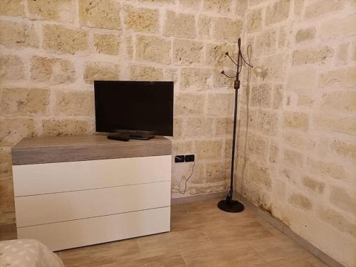Zimmer mit einem TV auf einer weißen Kommode in der Unterkunft Florooms Dimora in stile Rustico-Moderno in Corato