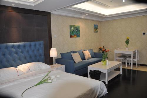 a bedroom with a blue bed and a couch at Ring Service Apartment 798 Art Zone in Beijing