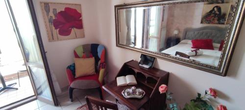 een slaapkamer met een spiegel, een bed en een stoel bij A casa di Ilde in Silvi Paese
