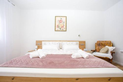 a bedroom with a large bed and a chair at New Charming Apartment Ivana - centrally located in Sinj