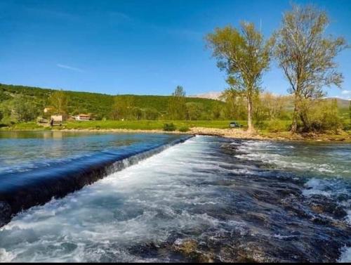 a river with water rushing over a retaining wall at New Charming Apartment Ivana - centrally located in Sinj