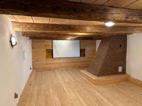 a large room with a tv on a brick wall at VAPARTMANY in Plumlov