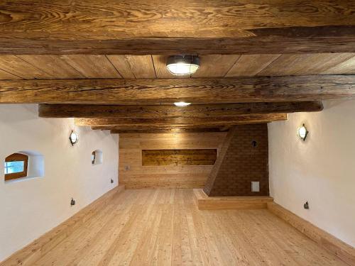 an empty room with wooden ceilings and a brick wall at VAPARTMANY in Plumlov