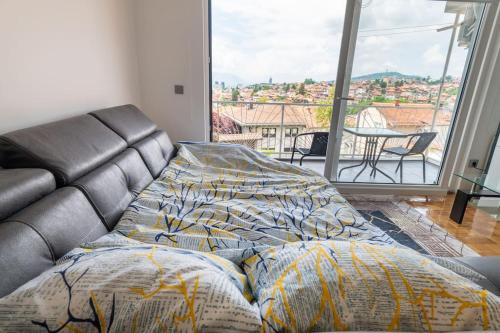 un letto in un soggiorno con una grande finestra di Apartment Aida No1 City view - Free Parking - a Sarajevo