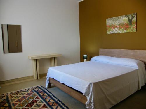 1 dormitorio con 1 cama y una pintura en la pared en La quiete di una villetta a 7 minuti a piedi dal mare, en Torre dell'Orso