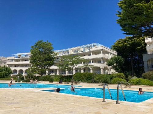 uma piscina em frente a um grande edifício em Studio à 300m de la plage, parc, piscine, terrasse em La Baule