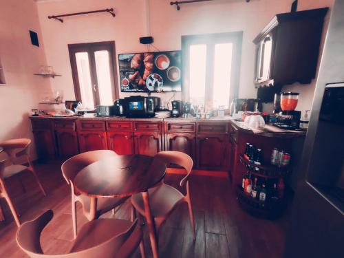 una cocina con armarios de madera, mesa y sillas en Jessica Flat GuestHouse , Holiday and Business, en Cospicua