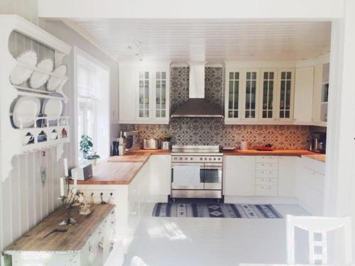 a kitchen with white cabinets and a stove top oven at Lenes hus in Halden