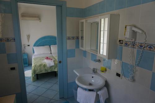 a bathroom with a sink and a bed at Hotel Da Giovanna in Lignano Sabbiadoro