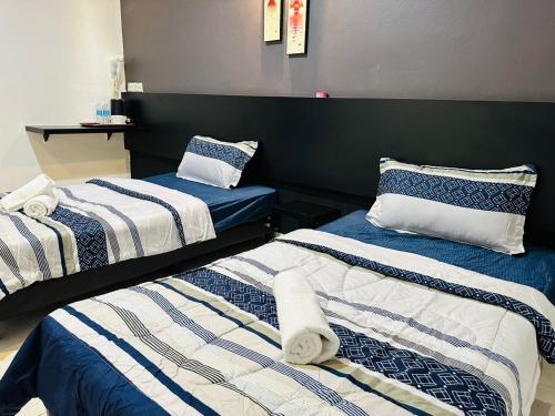 Dos camas en una habitación con toallas. en Kuu Inn Motel, en Arau
