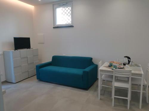 伊斯基亞的住宿－Casa Verdemare，客厅配有蓝色的沙发和桌子