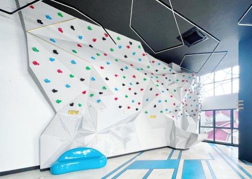a climbing wall in a room with a rock wall at Arte Plus Ampang By The Relaxstay in Kuala Lumpur