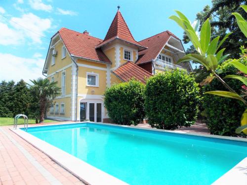 a house with a swimming pool in front of a house at Éden Villa Apartmanház in Balatonfüred