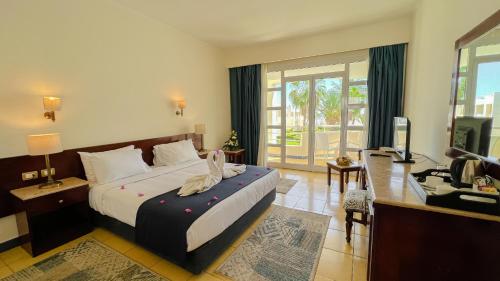 a bedroom with a bed and a desk and a television at Sharm Reef Resort in Sharm El Sheikh