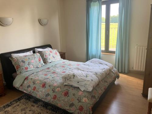 um quarto com uma cama e uma janela com cortinas azuis em 3 bedroom farmhouse in Normandy em Gathemo