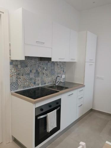 a white kitchen with a sink and a stove at Casa Verdemare in Ischia