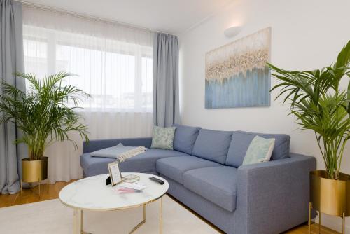 a living room with a blue couch and a table at RAFAEL KAISER - Premium Apartments City Centre - Contactless Check-In in Vienna