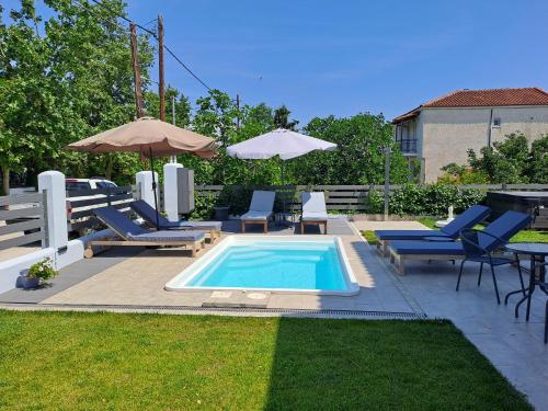 basen z leżakami i parasolem w obiekcie BIG BLUE HOTEL w mieście Amaliapoli