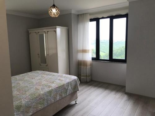 een slaapkamer met een bed en een groot raam bij MİRAY SUİTE VİLLA in Trabzon