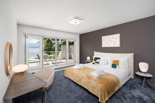 Park Villa Geneva - Swiss Hotel Apartments في جنيف: غرفة نوم بسرير كبير ونافذة كبيرة