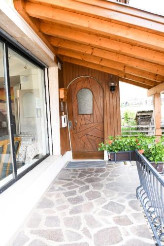 a wooden door on a house with a porch at Guesthouse Rosengarten in Dobbiaco
