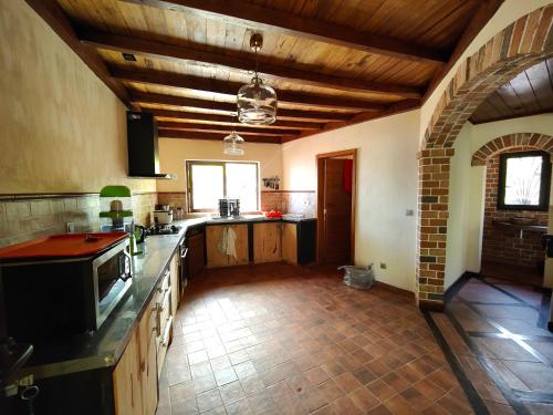 eine große Küche mit Holzböden und einer Holzdecke in der Unterkunft Villa Mbolatsara in Nosy Be