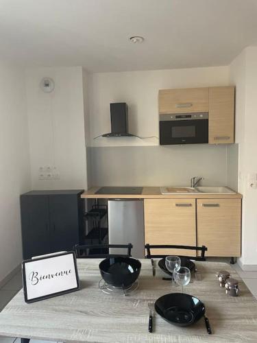 une cuisine avec une table avec des verres à vin dessus dans l'établissement Appartement 2 pièces, à Fréjus