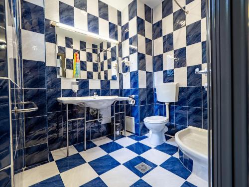 a blue and white bathroom with a toilet and a sink at Hotel Anca in Eforie Nord