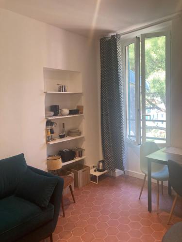 un salon avec un canapé, une table et une fenêtre dans l'établissement Duplex dans maison de village, à La Turbie
