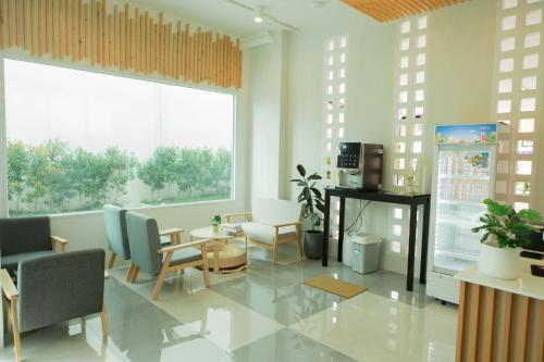 una stanza con sedie e tavolo e una grande finestra di S1 Trang Hotel a Trang