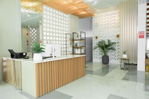 an office lobby with a reception desk and plants at S1 Trang Hotel in Trang