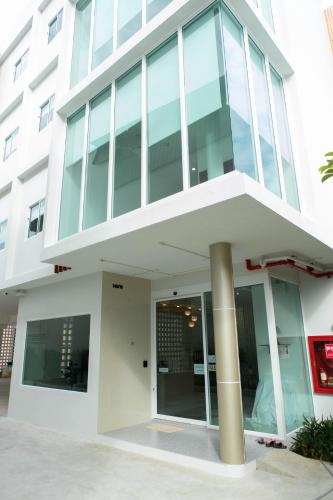 a large white building with glass windows at S1 Trang Hotel in Trang