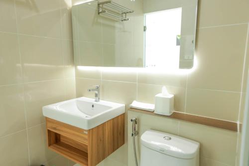 a bathroom with a sink and a toilet and a mirror at S1 Trang Hotel in Trang