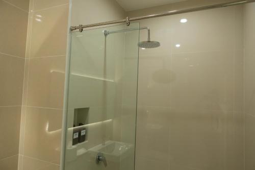 a shower with a glass door in a bathroom at S1 Trang Hotel in Trang