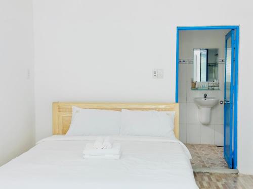 a bedroom with a large white bed with a sink at Ben's House 2 in Quy Thượng