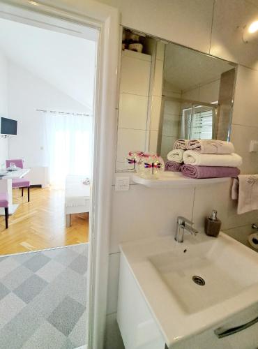 a bathroom with a sink and a mirror at Studio Apartments Regina in Bol