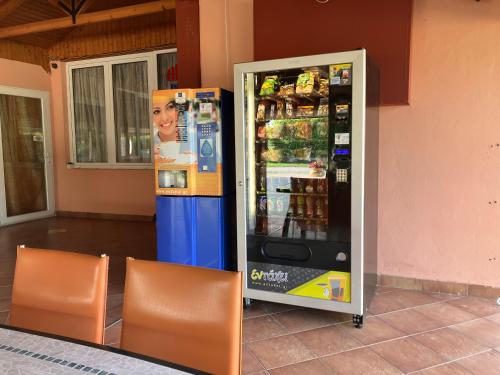 automat z napojami z dwoma krzesłami obok niego w obiekcie Hotel Avra w mieście Korinos