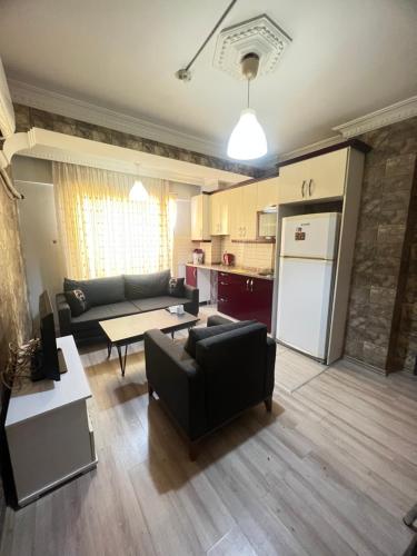 uma sala de estar com um sofá e uma cozinha em kızıl apart em Buca