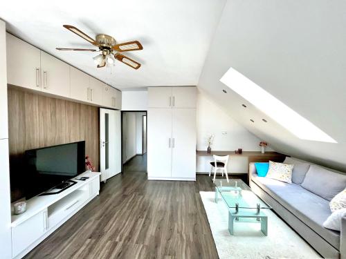 a living room with a couch and a ceiling fan at Holiday Apartment Žabovřesky in Hluboká nad Vltavou
