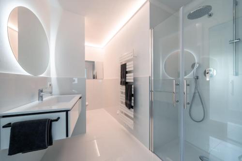 baño blanco con ducha y lavamanos en Villa Maria Boutique Apartment St Pauls, en Appiano sulla Strada del Vino