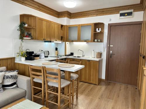 a kitchen with wooden cabinets and a counter top at Pirin Golf & Spa Greenside Studio in Razlog