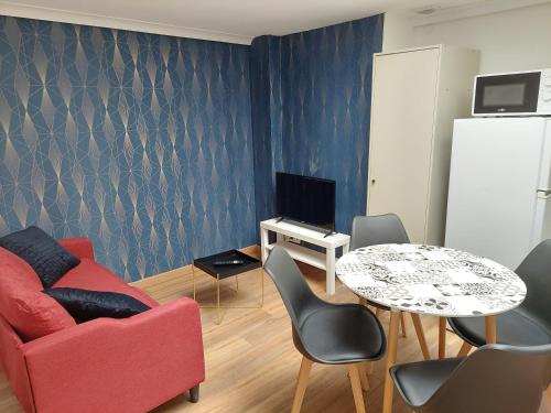 ein Wohnzimmer mit einem roten Sofa und einem Tisch in der Unterkunft ° Appart 4 - Lunéville centre ° in Lunéville