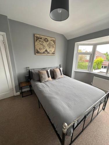 a bedroom with a large bed with a window at Fabulous 3bed off street parking in Stafford