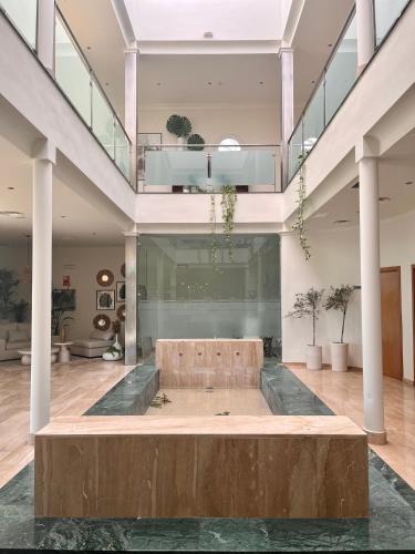 a large lobby with a bench in the middle of a room at Hotel Santa Ana in La Carlota