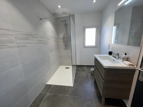 a white bathroom with a shower and a sink at Villa 100m2 Piscine 6 personnes in Châteauneuf-de-Gadagne