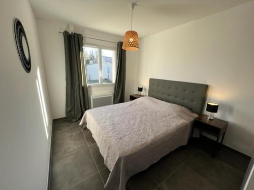 een slaapkamer met een bed en een raam bij Villa 100m2 Piscine 6 personnes in Châteauneuf-de-Gadagne