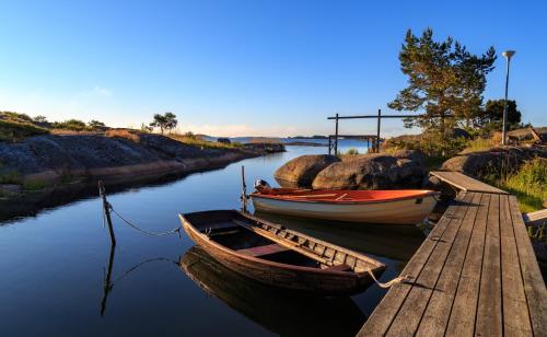 Dos barcos están atracados junto a un muelle. en Isakssons Cottage 7 en Föglö
