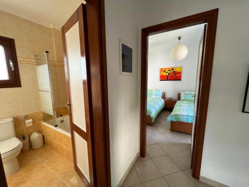 ein Bad mit einem WC und ein Schlafzimmer mit einem Bett in der Unterkunft Porto Hydra - Villa Mirani in Ermioni